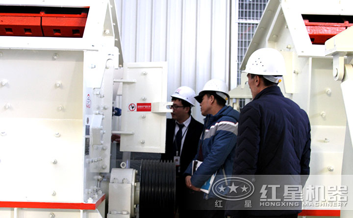 用戶在紅星碎石機(jī)設(shè)備廠區(qū)考察，技術(shù)經(jīng)理為其講解設(shè)備性能